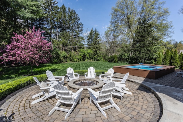 view of patio with a jacuzzi and an outdoor fire pit