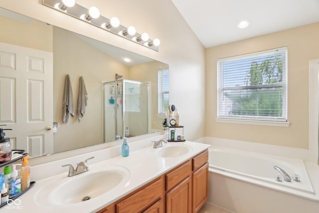 bathroom with a bath, a stall shower, and double vanity
