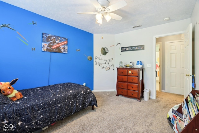 bedroom with carpet flooring, a textured ceiling, baseboards, and a ceiling fan