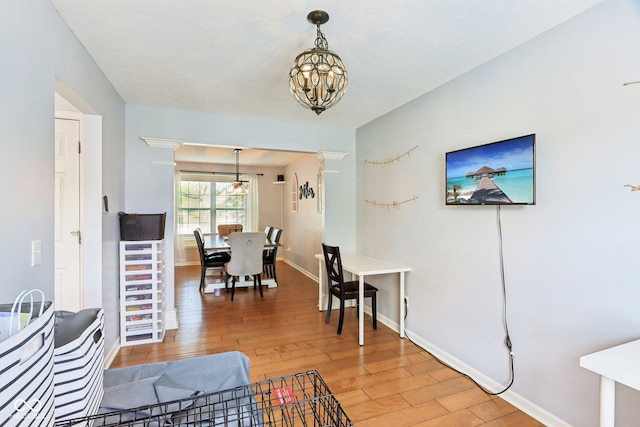 dining space with a chandelier, light wood-type flooring, and baseboards