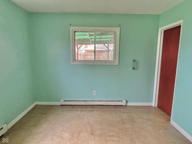 empty room featuring a baseboard heating unit and baseboards