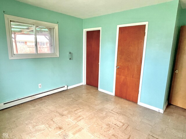unfurnished bedroom featuring baseboard heating and baseboards