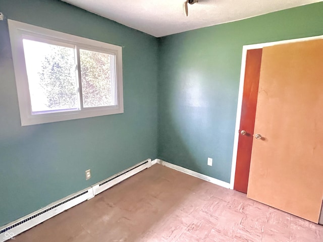spare room with a baseboard radiator and baseboards