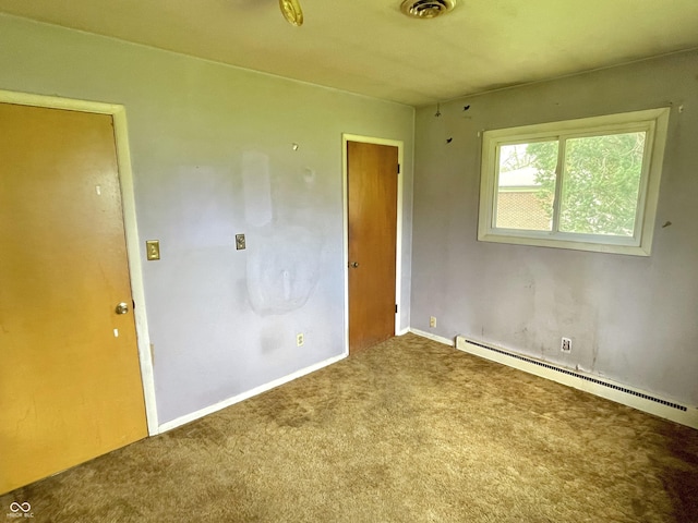 unfurnished room featuring a baseboard heating unit, baseboards, carpet, and visible vents
