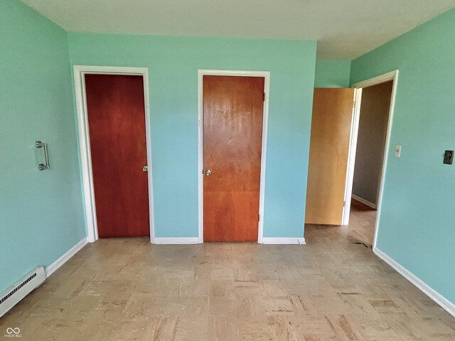 unfurnished bedroom featuring baseboards and baseboard heating