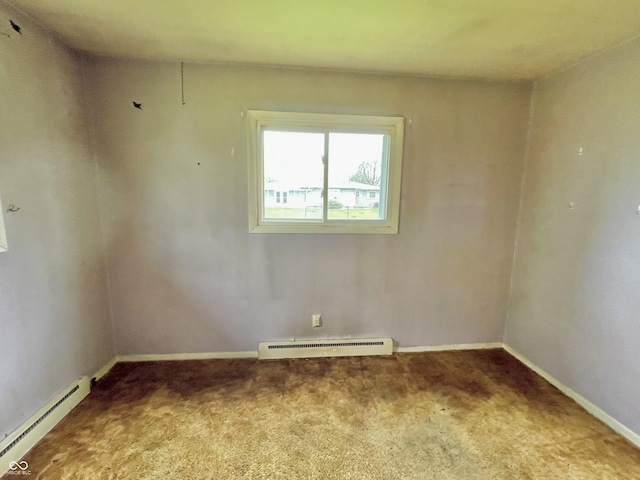 carpeted spare room with a baseboard radiator and baseboards
