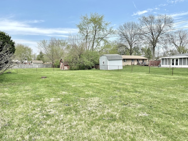 view of yard with a storage unit, an outbuilding, and fence