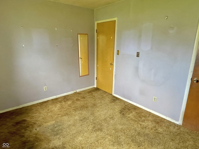 carpeted empty room featuring baseboards