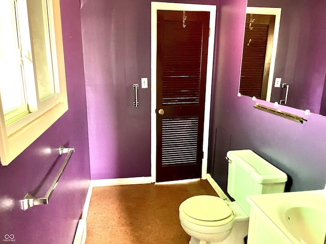 bathroom with vanity, toilet, and baseboards