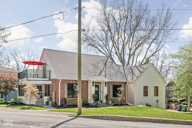 775 W Hawthorne St, Zionsville, IN 46077 - tudor house featuring brick siding, a balcony, roof with shingles, and a front lawn