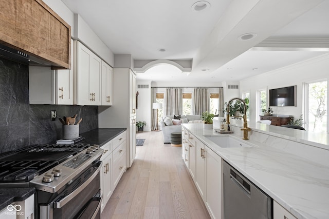 8551 E 300 S, Zionsville, IN 46077 - kitchen featuring a sink, stainless steel appliances, light wood-style floors, backsplash, and open floor plan