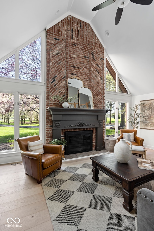 8551 E 300 S, Zionsville, IN 46077 - living area featuring a fireplace, high vaulted ceiling, a ceiling fan, visible vents, and wood finished floors