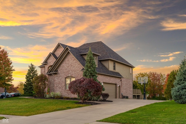 view of front of home featuring a garage, a front lawn, brick siding, and concrete driveway