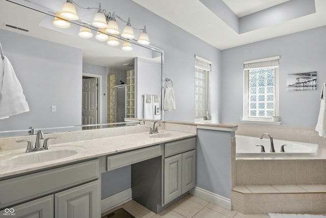 bathroom featuring double vanity, a garden tub, tile patterned flooring, and a sink