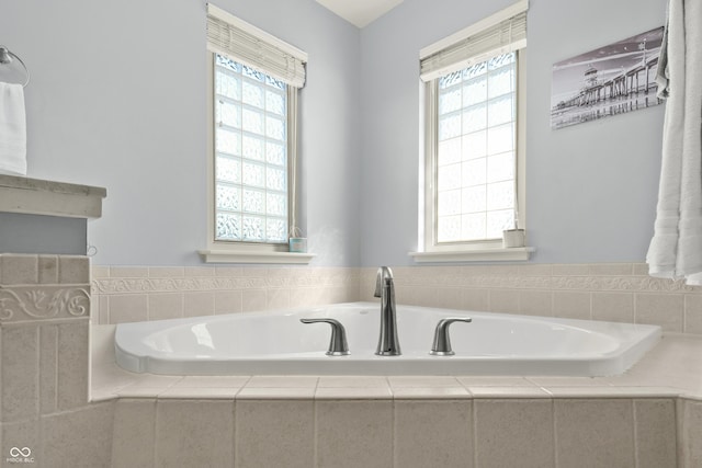 bathroom featuring a garden tub and a healthy amount of sunlight