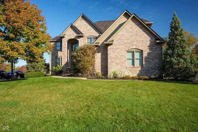 view of front of home featuring a front lawn and brick siding