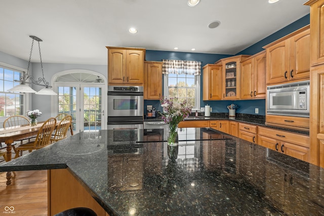 kitchen featuring glass insert cabinets, recessed lighting, appliances with stainless steel finishes, and a healthy amount of sunlight