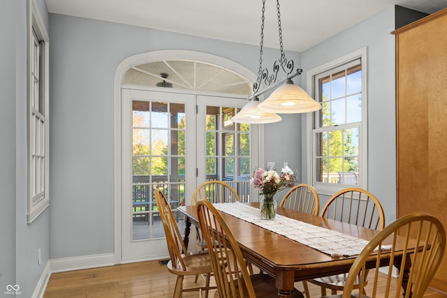 dining space with light wood finished floors and baseboards
