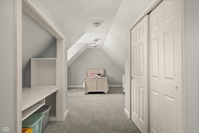 bedroom featuring vaulted ceiling, a closet, carpet flooring, and baseboards
