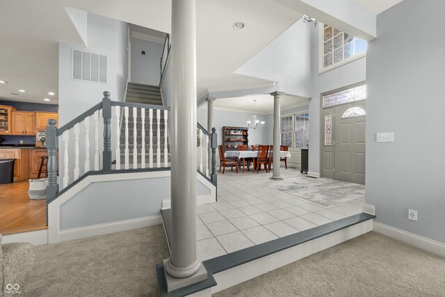 foyer with visible vents, an inviting chandelier, recessed lighting, ornate columns, and stairs