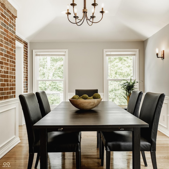 654 E 79th St, Indianapolis, IN 46240 - dining space with a chandelier, wainscoting, plenty of natural light, light wood-style floors, and a decorative wall
