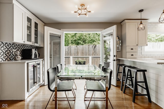 654 E 79th St, Indianapolis, IN 46240 - dining room with wine cooler, light wood-style floors, and a chandelier