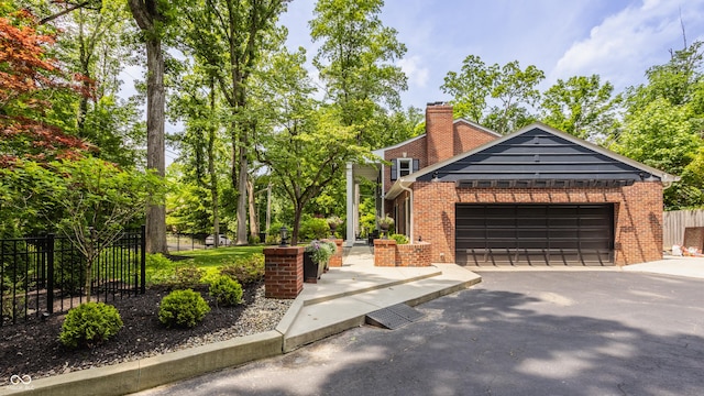 654 E 79th St, Indianapolis, IN 46240 - view of front of property with brick siding, a chimney, a garage, and asphalt driveway