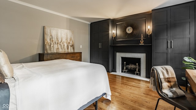654 E 79th St, Indianapolis, IN 46240 - bedroom featuring ornamental molding, a brick fireplace, and light wood-style floors