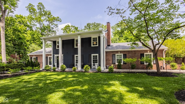 654 E 79th St, Indianapolis, IN 46240 - greek revival inspired property featuring a chimney, brick siding, a front yard, and covered porch