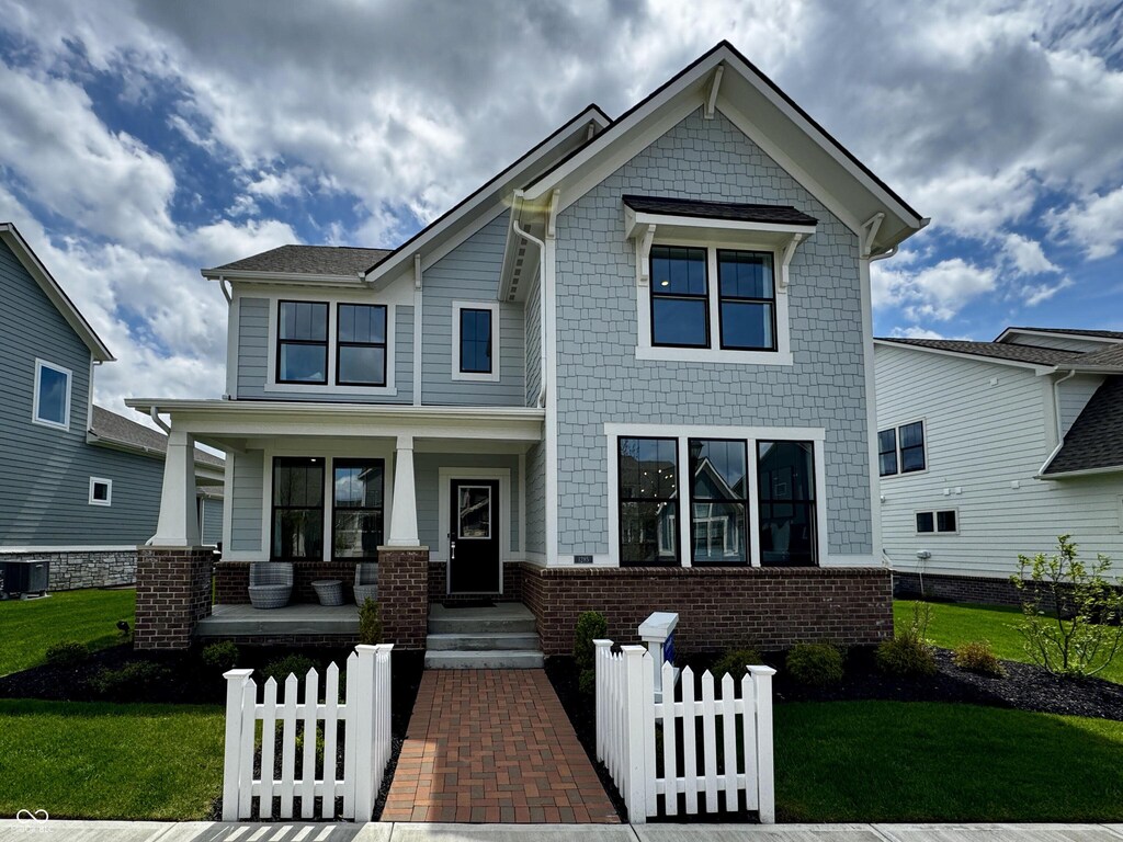 craftsman house featuring a porch, a front lawn, and fence