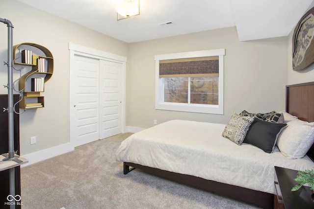 carpeted bedroom with a closet, baseboards, and visible vents