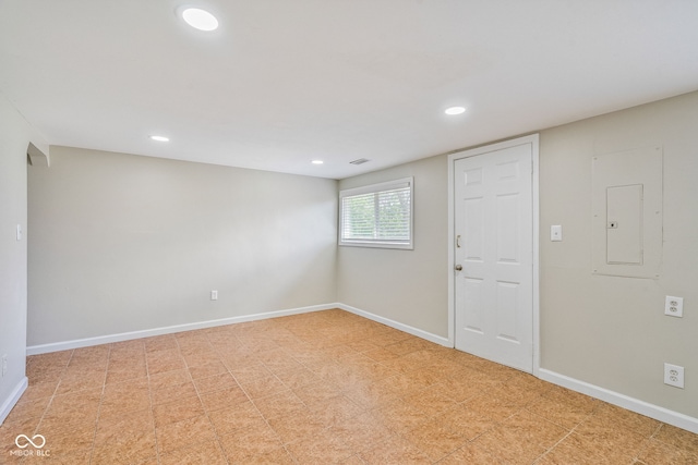 unfurnished room with recessed lighting, electric panel, and baseboards