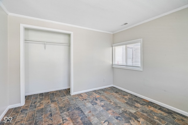 unfurnished bedroom with a closet, crown molding, and baseboards