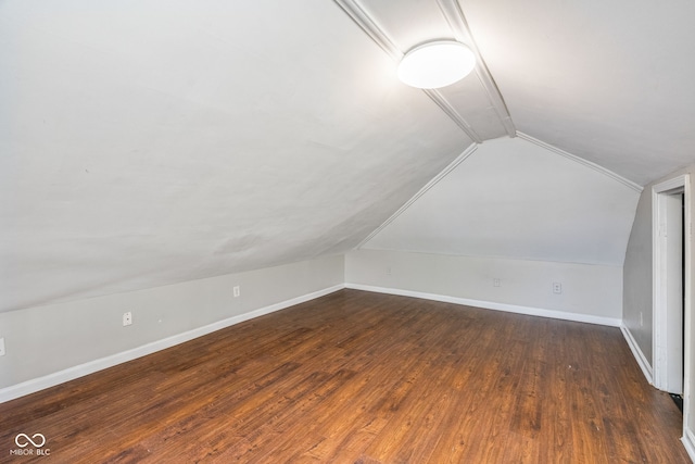 bonus room featuring lofted ceiling, dark wood-type flooring, and baseboards