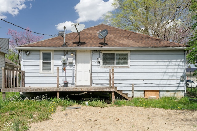 back of property featuring a deck and roof with shingles