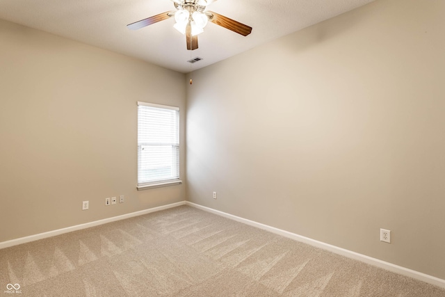 carpeted empty room featuring baseboards and a ceiling fan