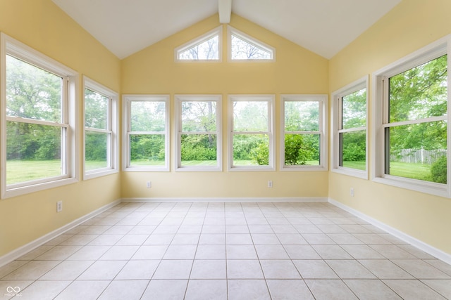 unfurnished sunroom with tile patterned flooring, plenty of natural light, vaulted ceiling, and baseboards