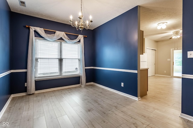 spare room with a chandelier, wood finished floors, baseboards, ceiling fan, and a textured ceiling