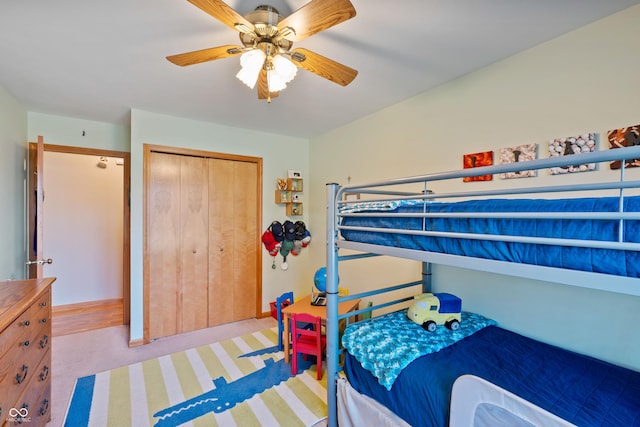 carpeted bedroom featuring a closet and ceiling fan
