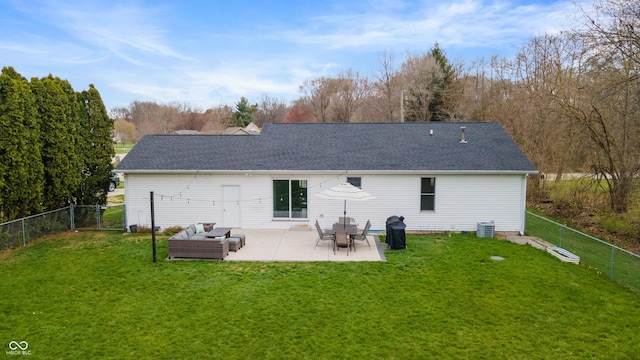 back of house featuring a yard, a patio area, a shingled roof, and a fenced backyard