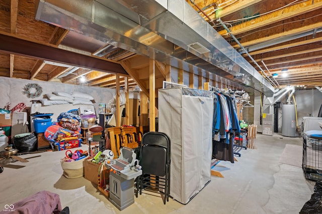 unfinished below grade area with water heater, heating unit, and washer / clothes dryer