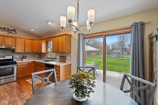 kitchen with backsplash, appliances with stainless steel finishes, a notable chandelier, and a sink