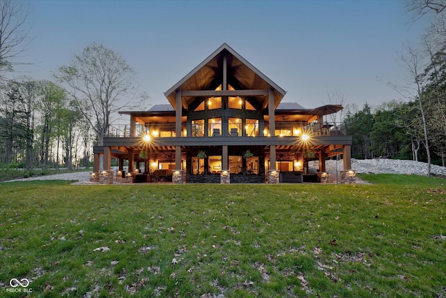 back of property featuring a yard and stone siding