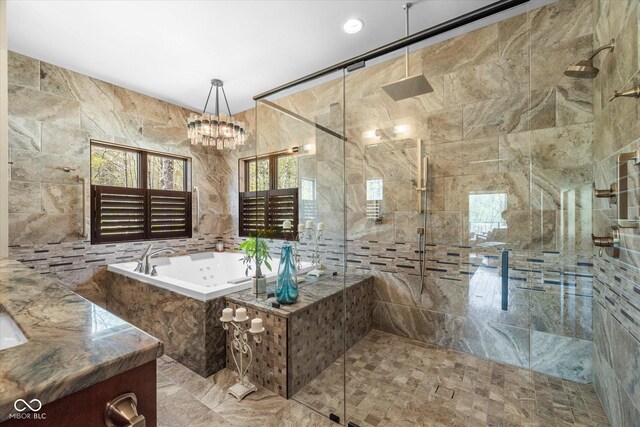 bathroom featuring tile walls, a shower stall, a bath, and a chandelier