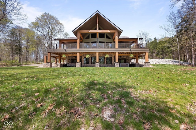 rear view of property featuring a yard, stone siding, and a deck