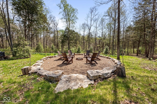 view of grassy yard with an outdoor fire pit