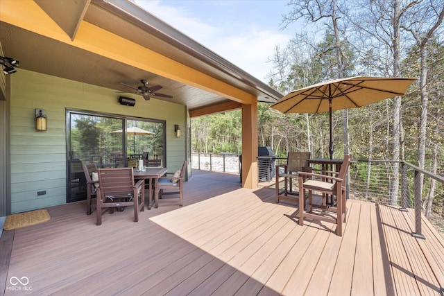 deck featuring outdoor dining area and ceiling fan