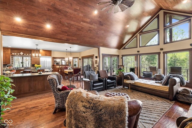 living room with a chandelier, hardwood / wood-style floors, plenty of natural light, high vaulted ceiling, and wooden ceiling