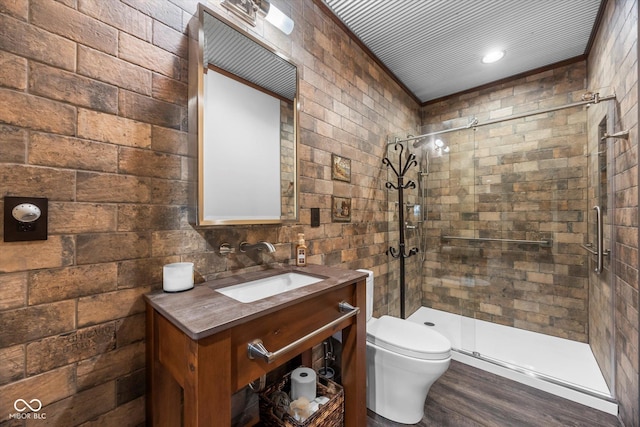 bathroom featuring a shower stall, toilet, wood finished floors, and vanity