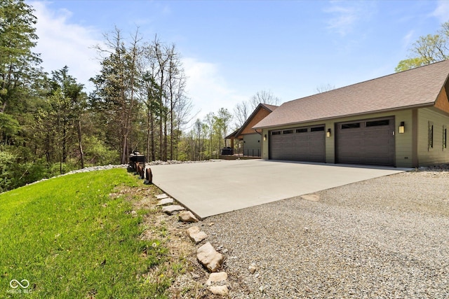 view of property exterior with driveway and roof with shingles